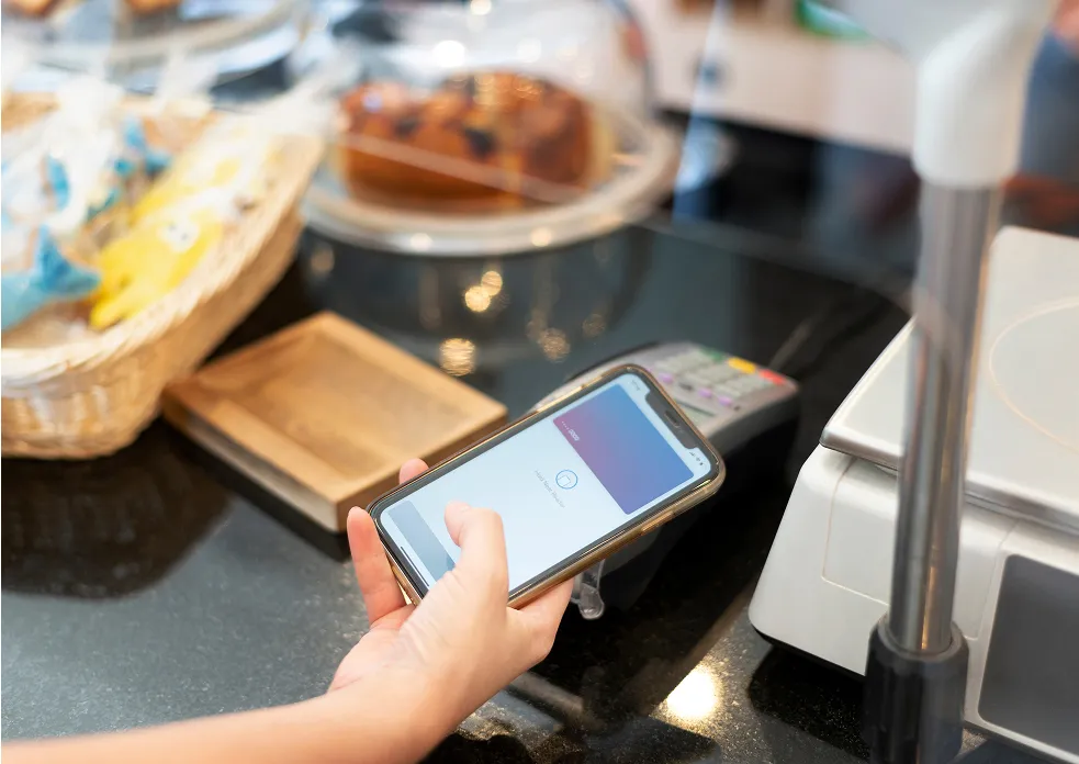 cliente qui paye par tap to pay à un comptoir