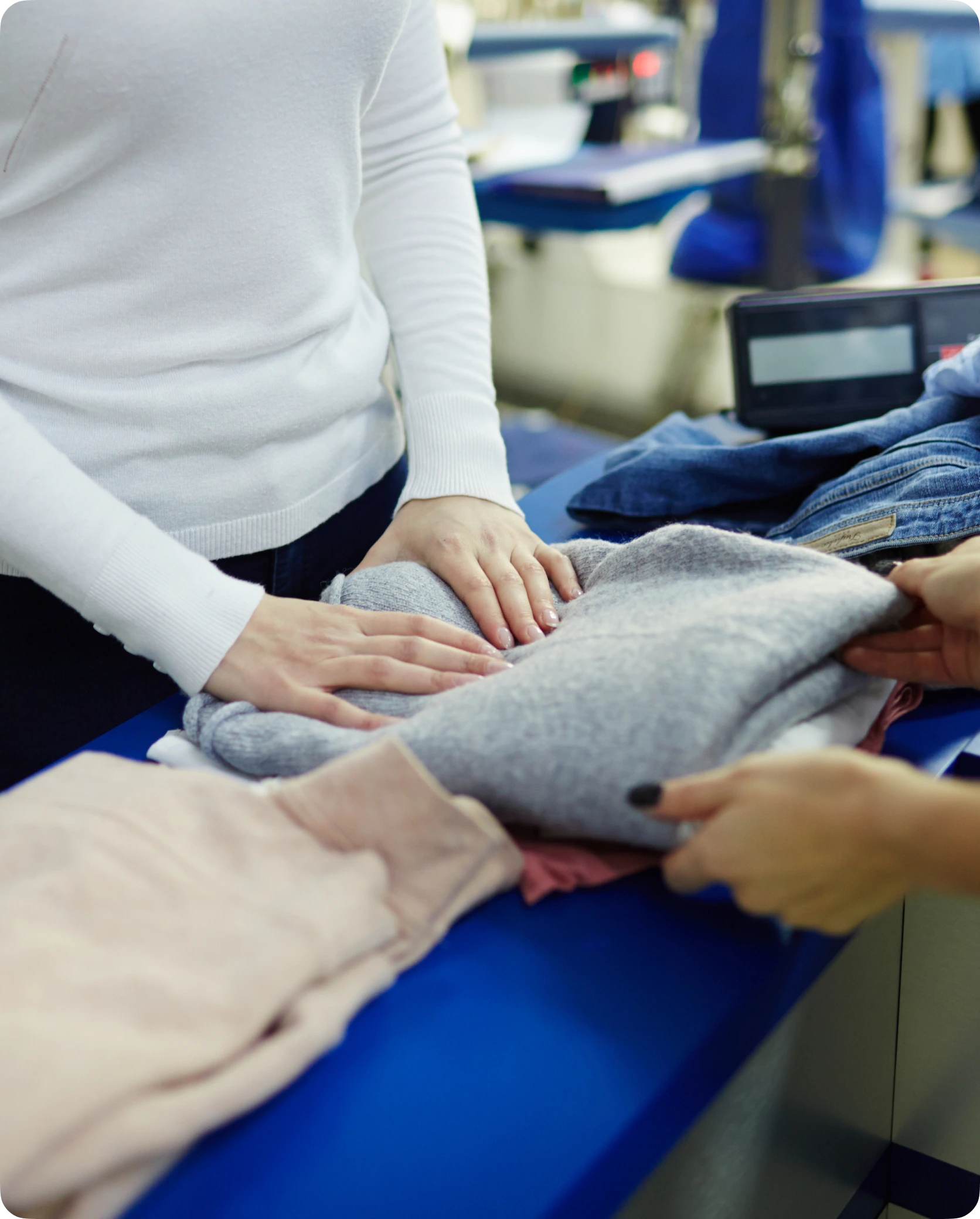une cliente regarde un pull gris dans un maagsin